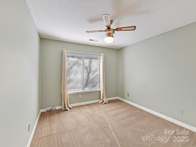 empty room featuring visible vents, baseboards, ceiling fan, carpet flooring, and a textured ceiling