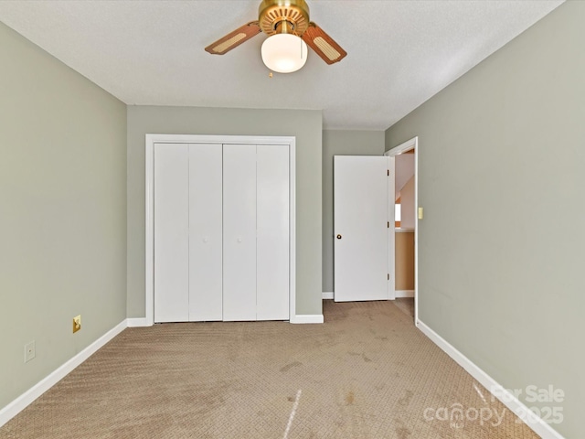 unfurnished bedroom with a closet, baseboards, carpet floors, and ceiling fan