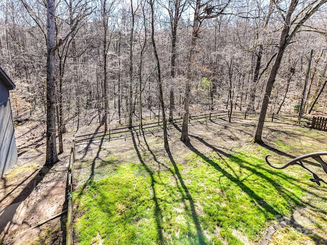 exterior space with fence and a wooded view