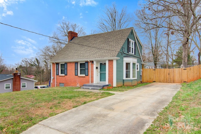 view of front of property featuring fence, a shingled roof, a chimney, a front lawn, and brick siding