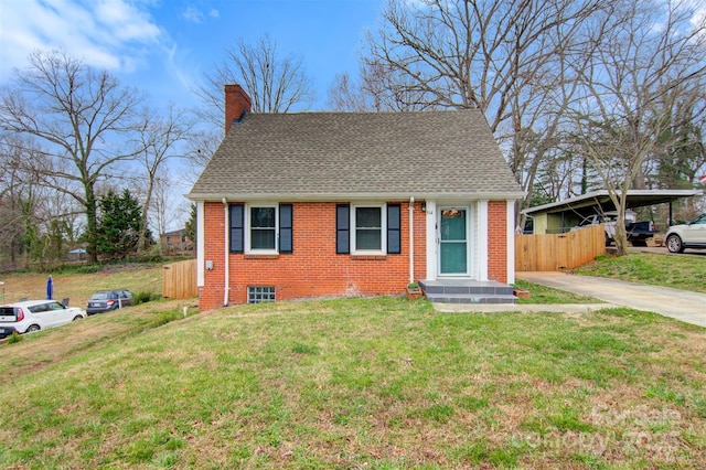 view of front facade with a front lawn, fence, a shingled roof, brick siding, and a chimney