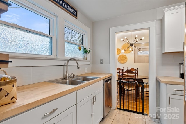 kitchen featuring a sink, tasteful backsplash, stainless steel dishwasher, and butcher block counters