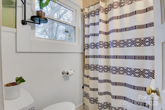 full bathroom featuring a shower with shower curtain and toilet