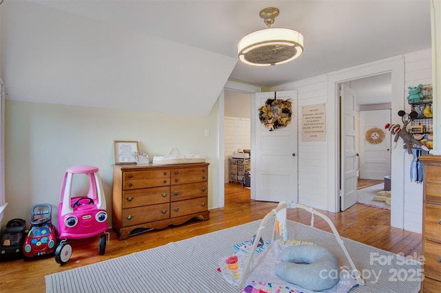 bedroom with lofted ceiling and wood finished floors