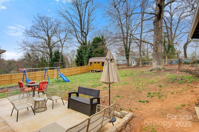 view of yard with a patio area, a fenced backyard, and a playground