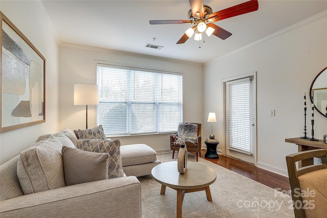 living room featuring crown molding, wood finished floors, visible vents, and baseboards