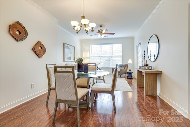 dining space featuring ceiling fan with notable chandelier, crown molding, baseboards, and dark wood-style flooring