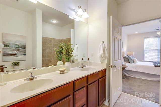 ensuite bathroom with a sink, ensuite bath, double vanity, and tile patterned flooring