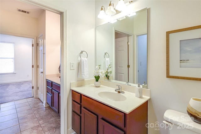 bathroom featuring vanity, toilet, visible vents, and tile patterned flooring