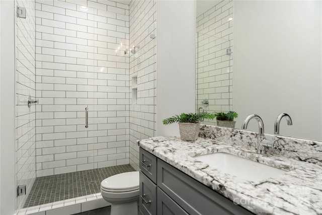 full bathroom with toilet, a stall shower, and vanity