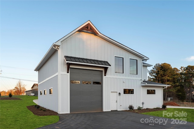 view of side of home featuring a yard, board and batten siding, metal roof, and a standing seam roof