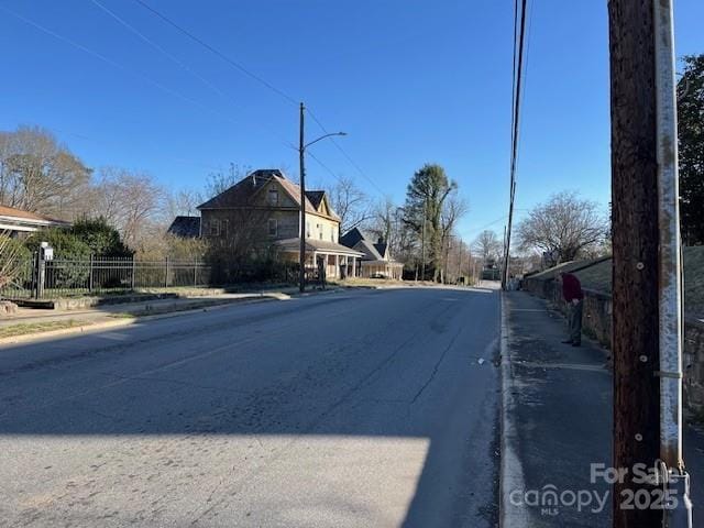 view of road with curbs, street lights, and sidewalks