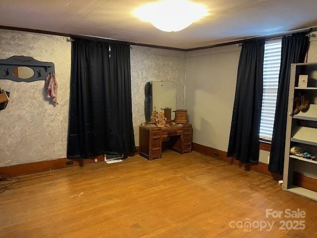 interior space with baseboards and wood finished floors