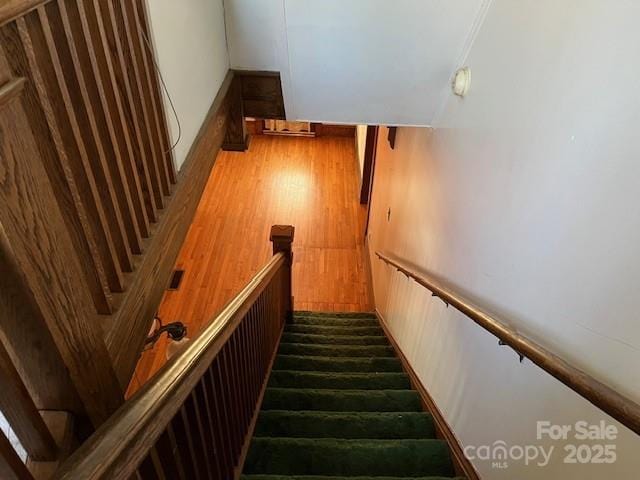 stairs featuring wood finished floors