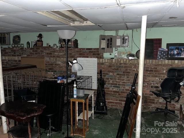 miscellaneous room featuring brick wall and concrete flooring