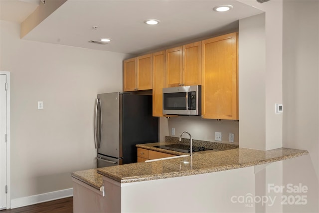 kitchen with light stone counters, visible vents, a peninsula, recessed lighting, and appliances with stainless steel finishes