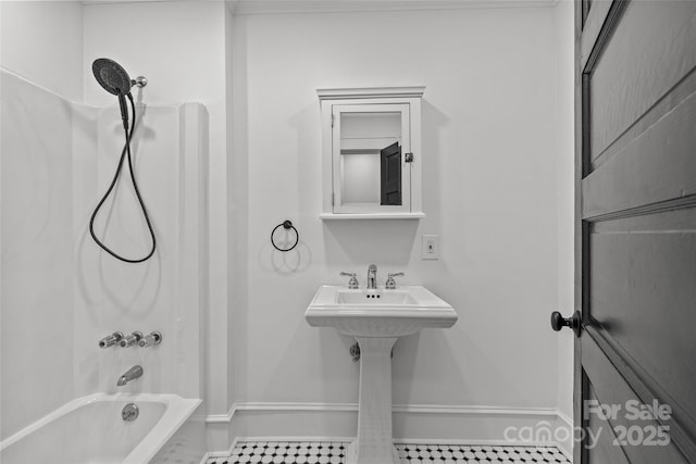 bathroom featuring tub / shower combination and baseboards