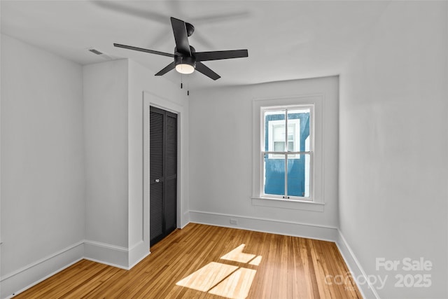 unfurnished bedroom featuring visible vents, baseboards, ceiling fan, light wood-style floors, and a closet