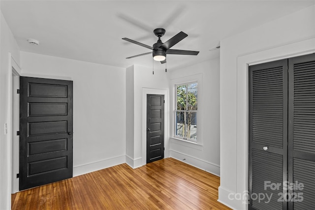 unfurnished bedroom with light wood-type flooring, baseboards, a closet, and ceiling fan