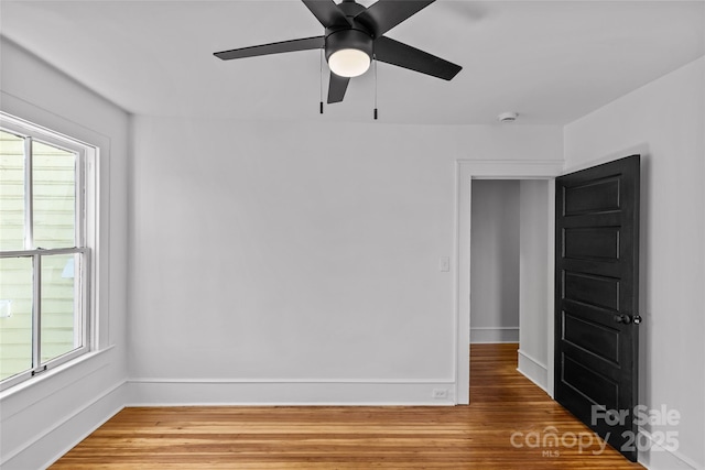 unfurnished room with baseboards, plenty of natural light, and light wood-style floors