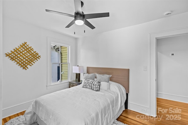 bedroom featuring baseboards, ceiling fan, and wood finished floors