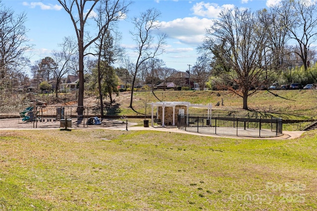 view of yard featuring playground community and fence