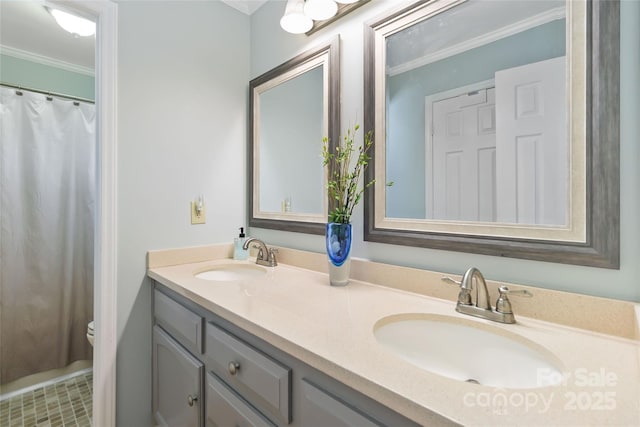 full bath with a sink, toilet, ornamental molding, and double vanity