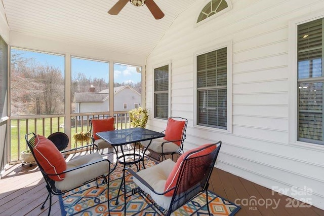 sunroom featuring a healthy amount of sunlight, a ceiling fan, and vaulted ceiling