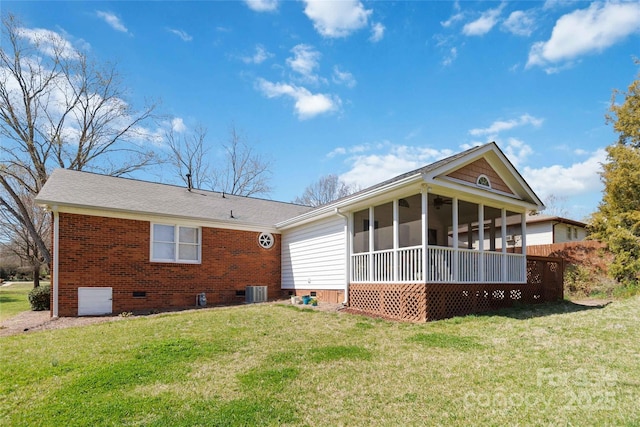 back of property with an attached garage, a yard, a sunroom, crawl space, and brick siding