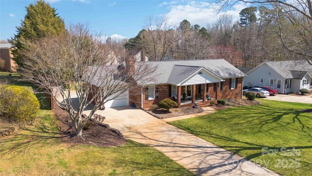 single story home featuring covered porch, a chimney, a front lawn, concrete driveway, and brick siding