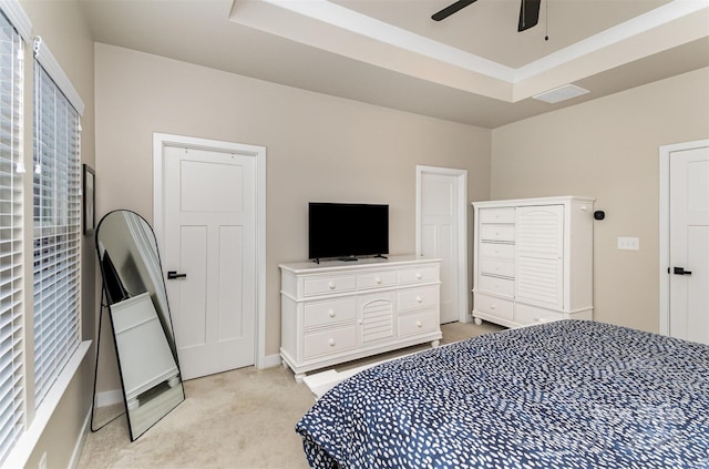 bedroom featuring visible vents, light carpet, a raised ceiling, and baseboards