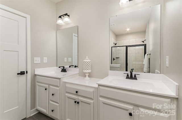 full bath featuring a sink, double vanity, and a shower stall