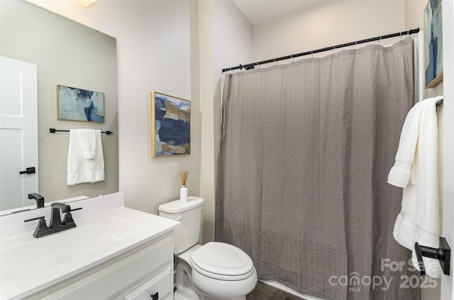 full bath featuring vanity, a shower with shower curtain, and toilet