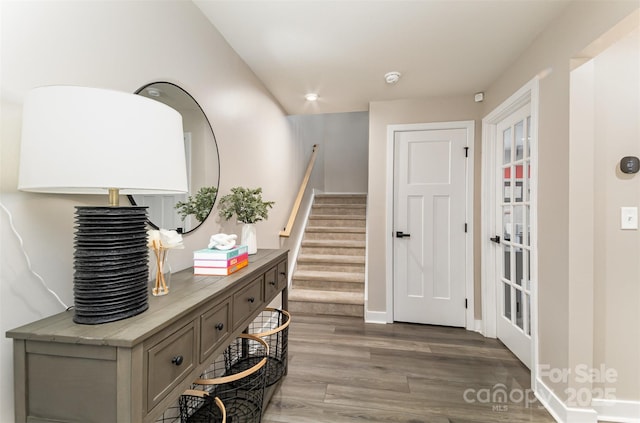 entrance foyer with stairs, wood finished floors, and baseboards