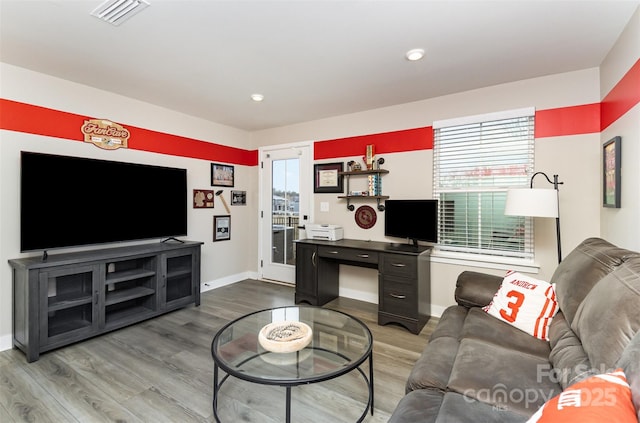 living area featuring wood finished floors, visible vents, and baseboards