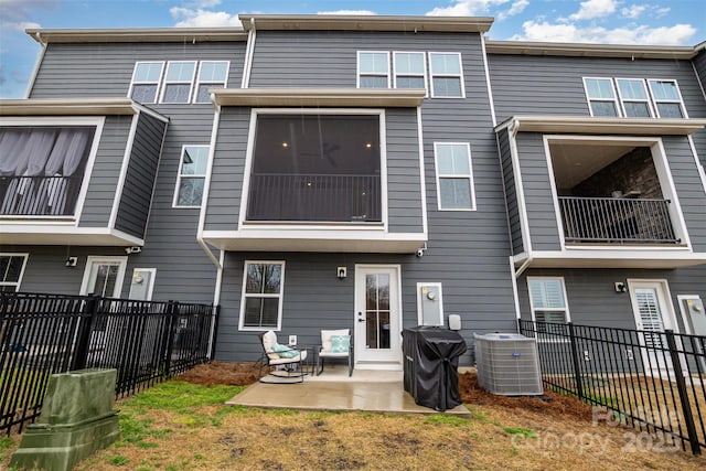 rear view of house featuring fence, central AC, and a patio area