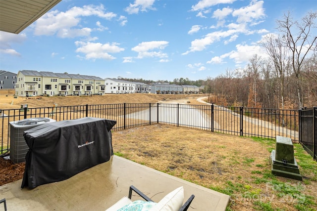 view of yard with central air condition unit, a residential view, a fenced backyard, and a patio area