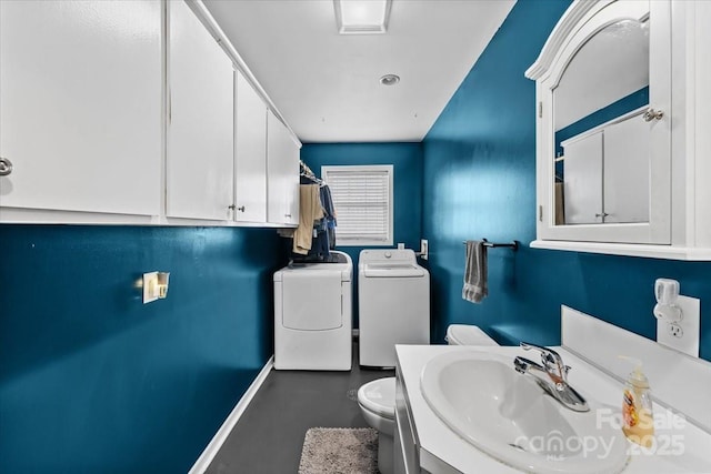 bathroom featuring washer and dryer, toilet, vanity, and baseboards