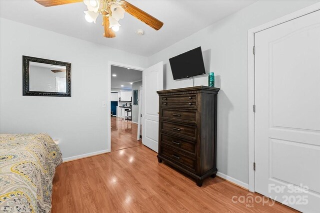 bedroom featuring light wood-style flooring, a ceiling fan, and baseboards