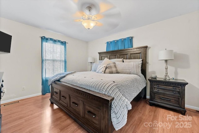 bedroom featuring visible vents, light wood-style flooring, baseboards, and ceiling fan