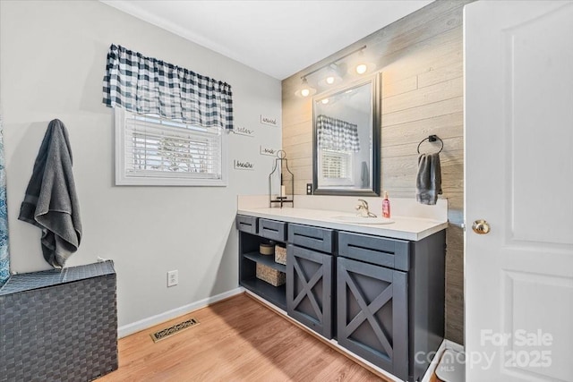 bathroom featuring visible vents, baseboards, wood finished floors, and vanity