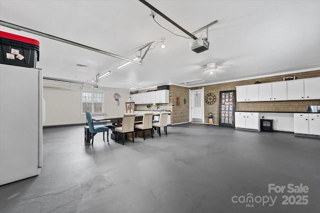 garage with a garage door opener and freestanding refrigerator