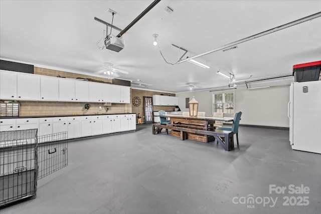 garage with a garage door opener and freestanding refrigerator