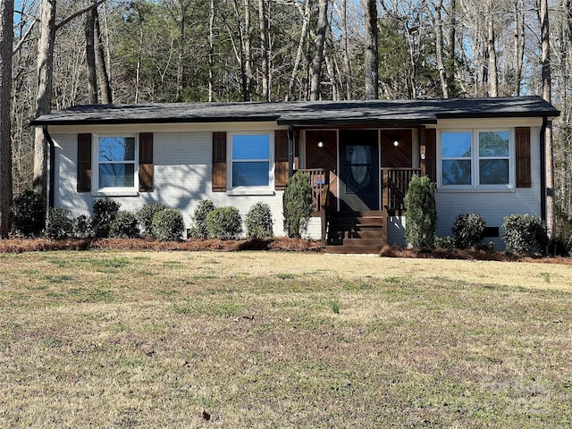 view of front of home with brick siding, covered porch, and a front lawn