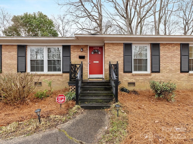 view of front facade featuring crawl space and brick siding