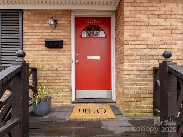 doorway to property with brick siding