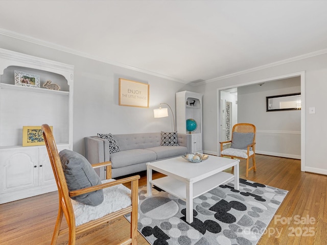 living room with baseboards, wood finished floors, and ornamental molding