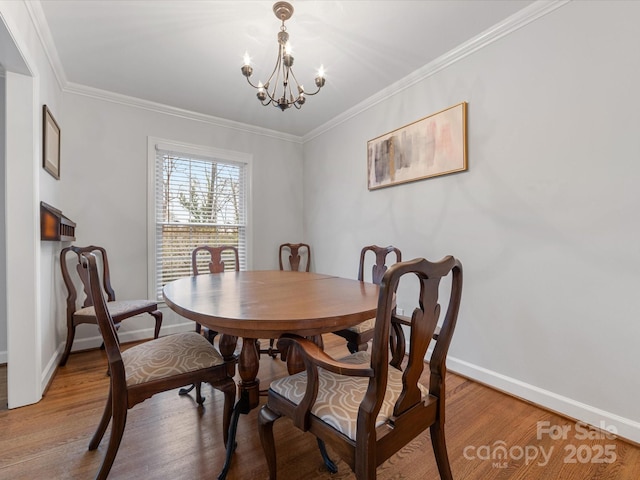 dining space featuring an inviting chandelier, baseboards, light wood-style floors, and ornamental molding