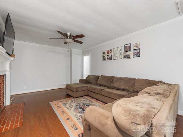 living area featuring a fireplace with flush hearth, wood finished floors, baseboards, and ornamental molding