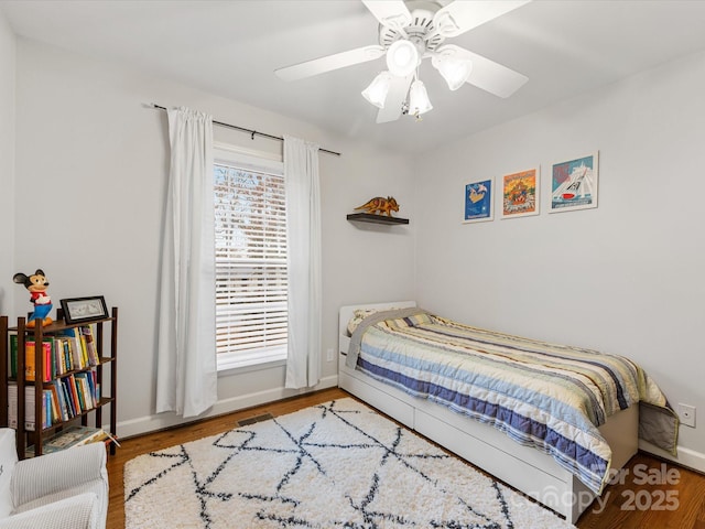 bedroom featuring ceiling fan, baseboards, and wood finished floors